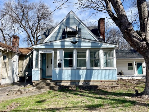 A blue house with the number 717 on the front door.