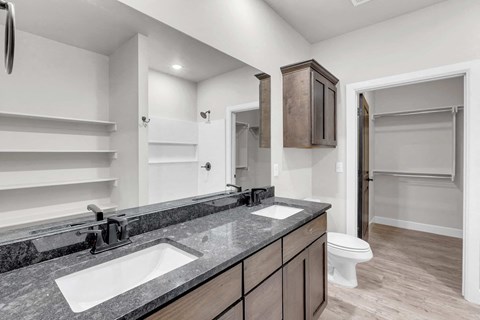 a bathroom with two sinks and a toilet