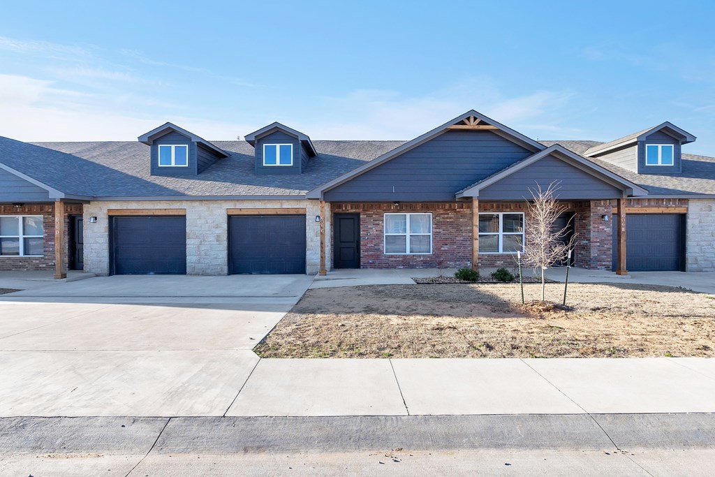 a house with two garage doors and a sidewalk in front of it
