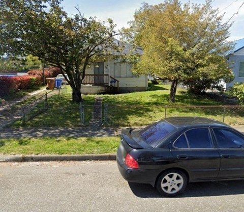 a car parked on the street in front of a house