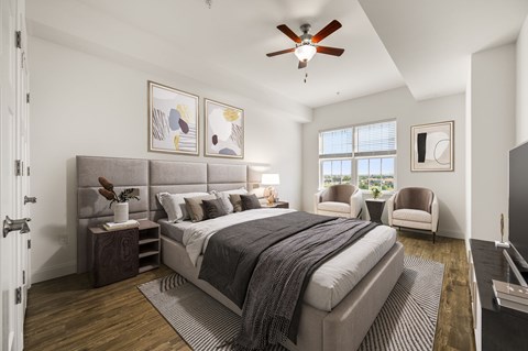 A bedroom with a large bed and a ceiling fan.