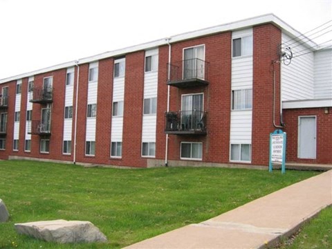 A red brick building with a sign in front.