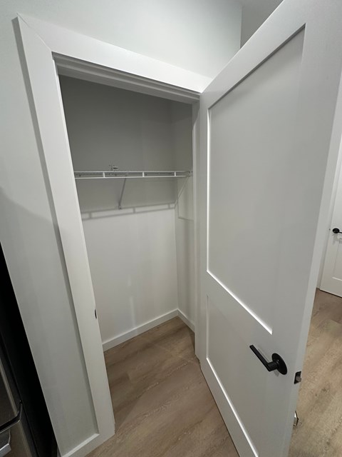 A white door is open to a small closet.