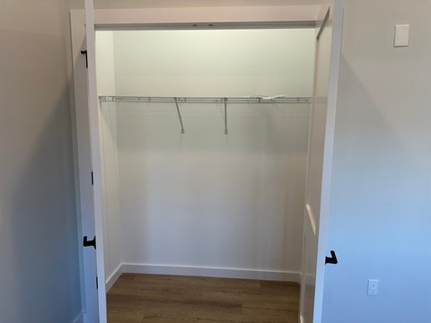 A white closet with a light on.