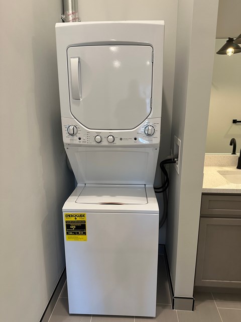 A white dryer is sitting in a bathroom.