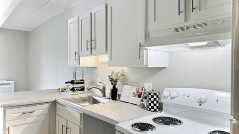 an empty kitchen with white cabinets and white appliances
