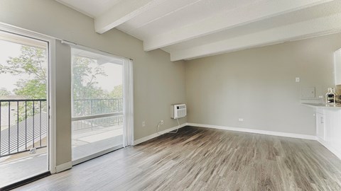 an empty living room with wood flooring and a white door