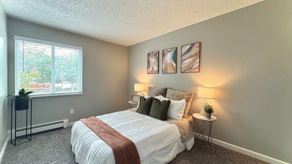 two picnic tables with umbrellas in front of a swimming pool