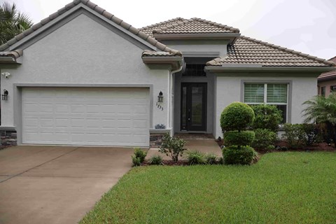 a house with a driveway and a garage door in front of it