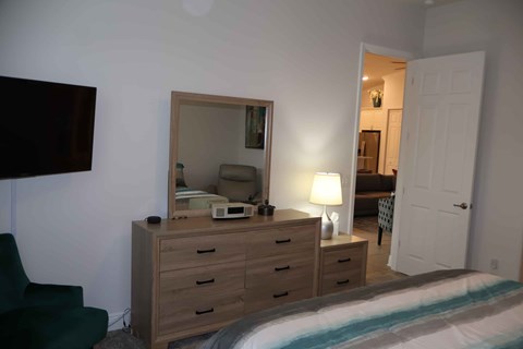 a bedroom with a bed and a mirror and a dresser