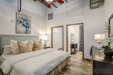 A bedroom with a large bed and a painting on the wall.