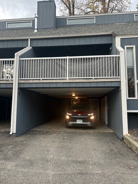 A car is parked in a garage attached to a house.