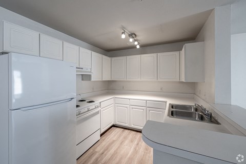A kitchen with white appliances and cabinets.