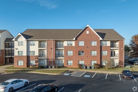 A large brick building with a parking lot in front.