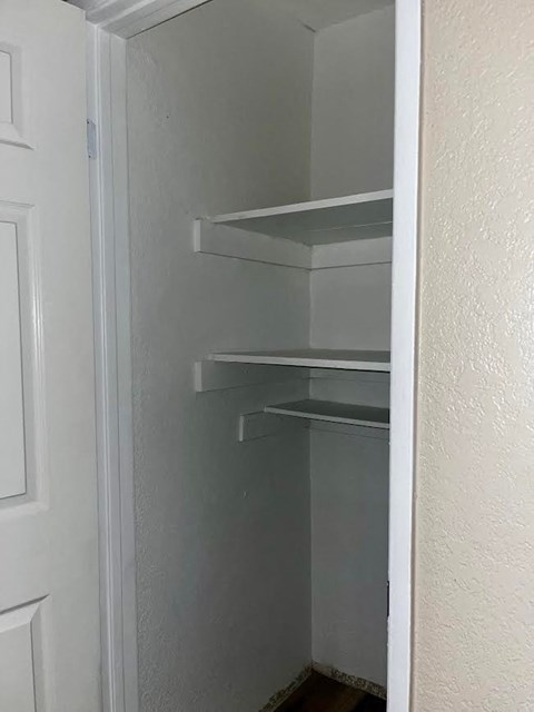 an empty closet with shelves on the wall