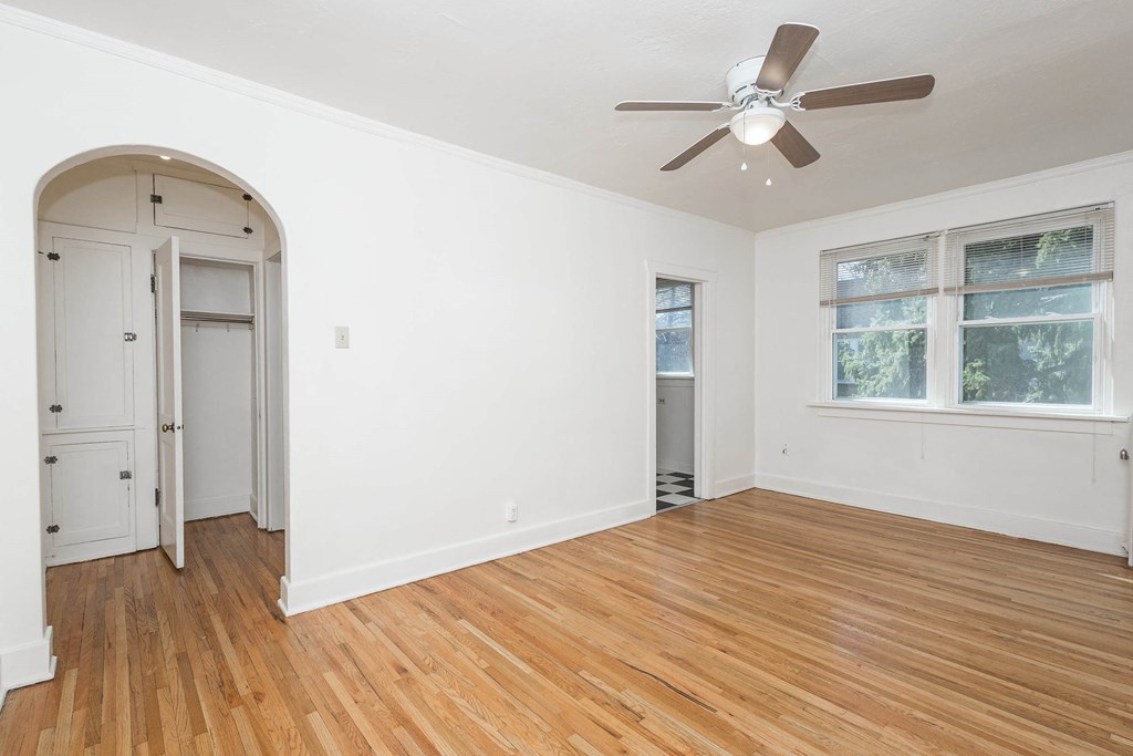A room with a ceiling fan and a window.