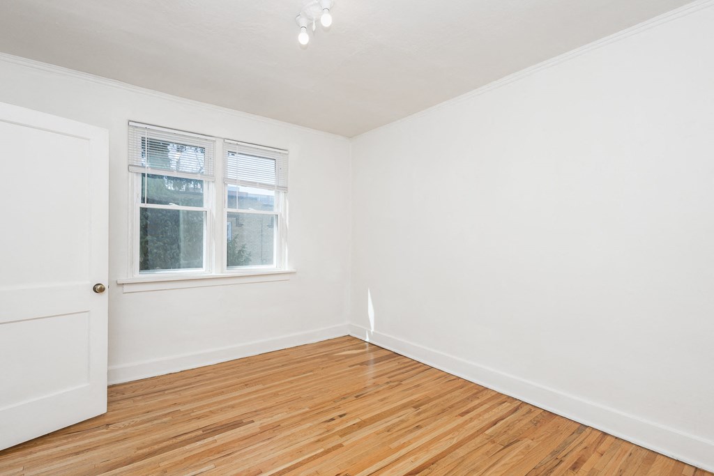 A room with a white door and a window with blinds.