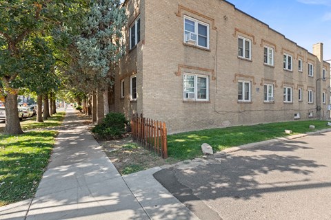the side of a brick building with a sidewalk in front of it