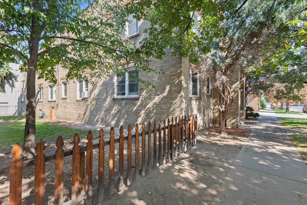 an old brick house with a fence in front of it