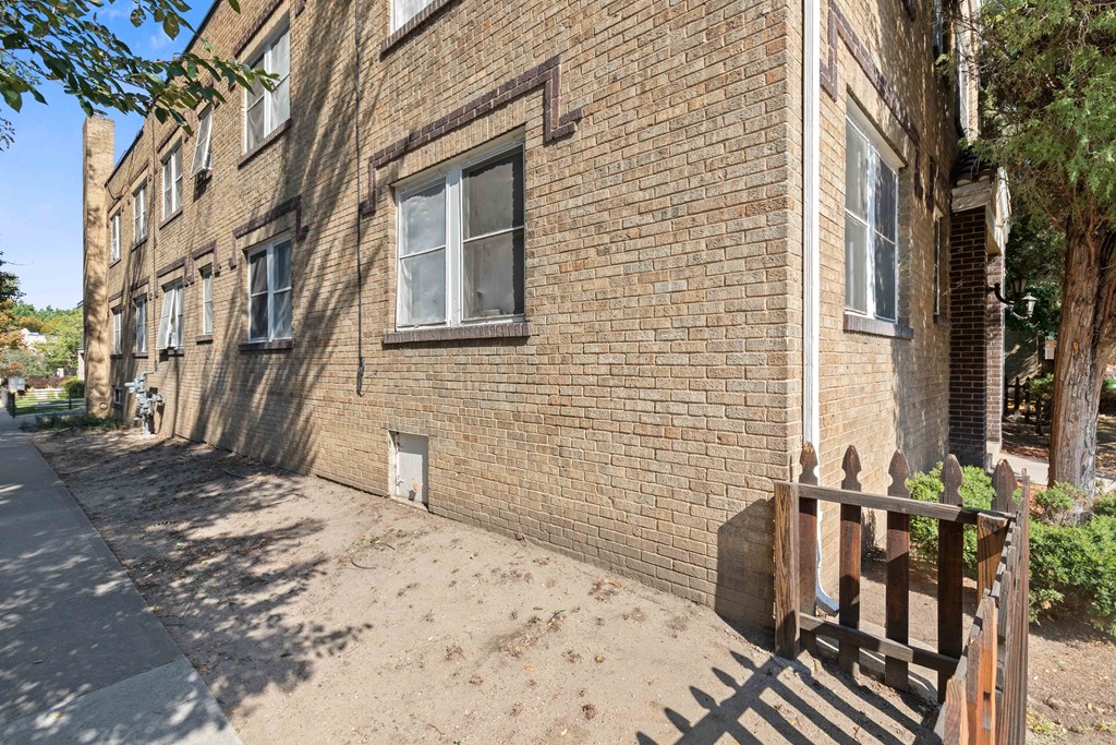 the side of a brick building with a wooden gate