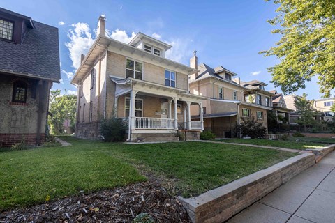 the front of a house with a yard and a sidewalk