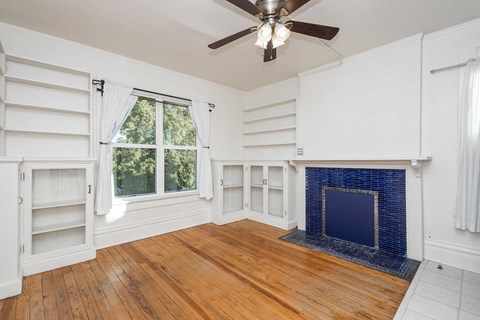 A room with a fireplace and wooden floors.