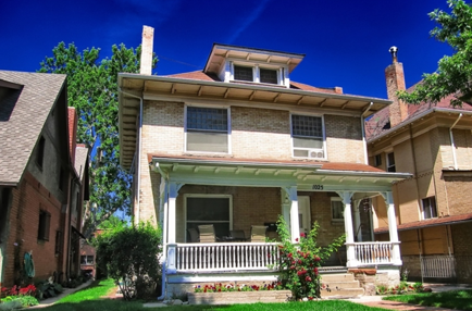 an old brick house with a white porch