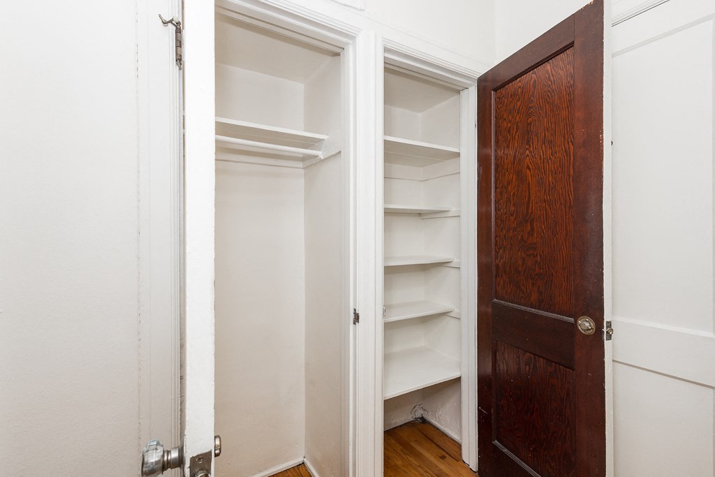 A white door is open to a room with a brown door.