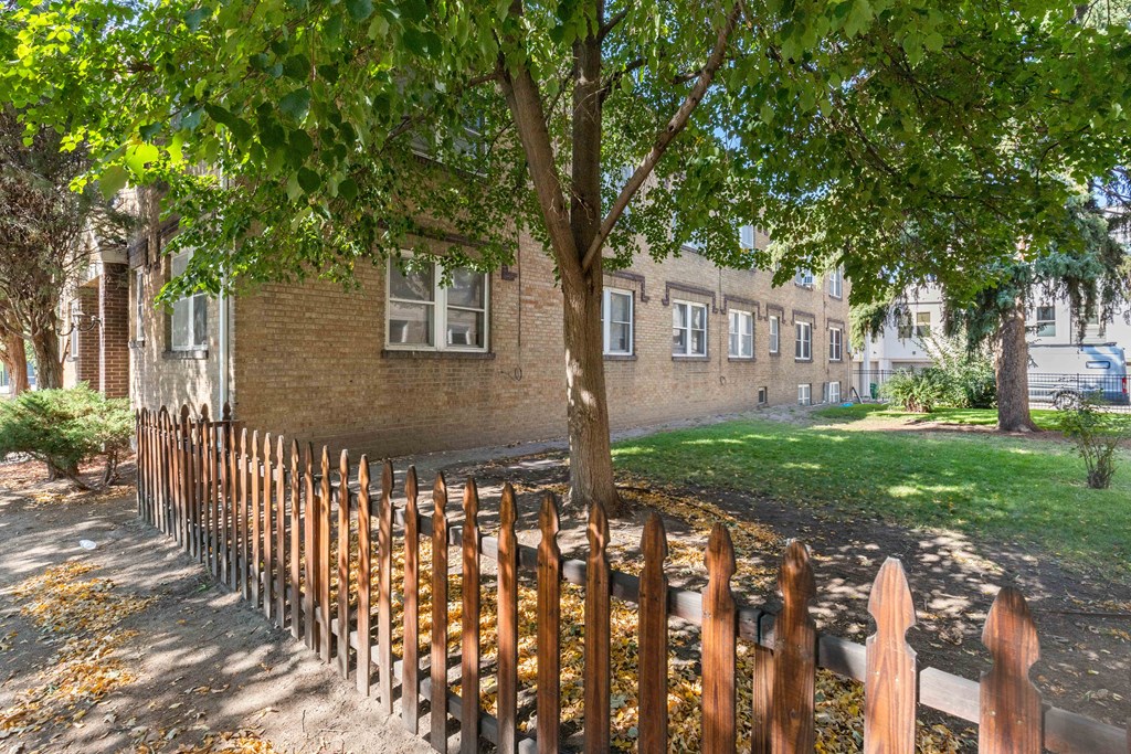 a wooden fence in front of a brick building