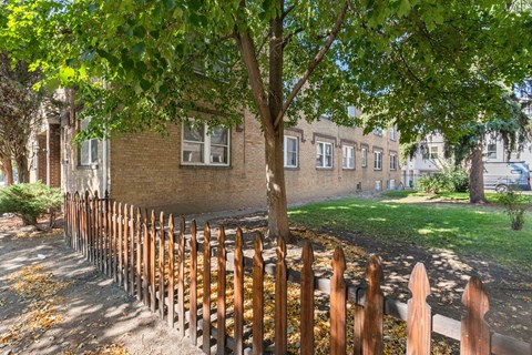 a wooden fence in front of a brick building