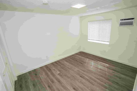 a bedroom with green walls and a wood floor