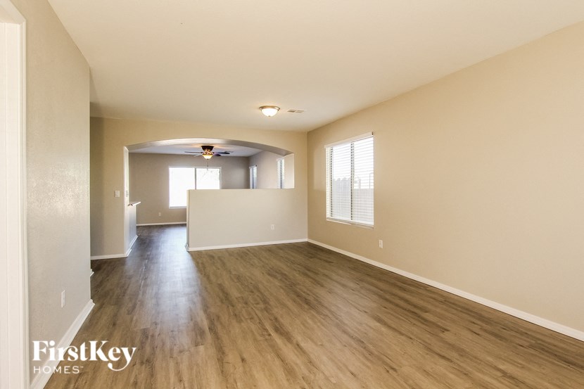 the living room and dining room of an empty house with wood flooring