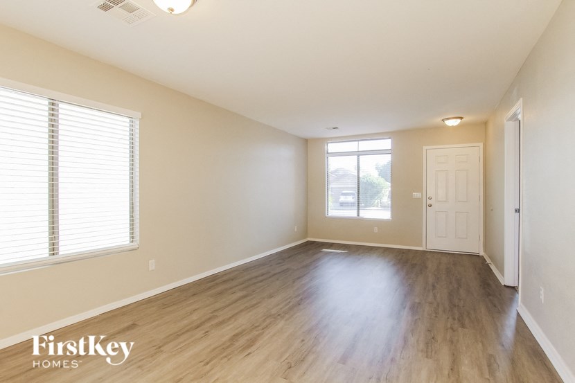 the living room and dining room of an empty house with wood flooring