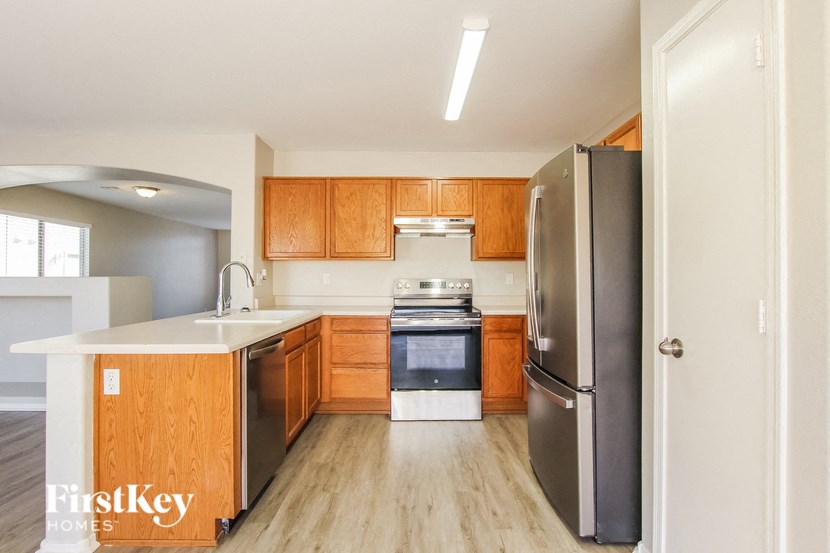 a kitchen with wooden cabinets and stainless steel appliances