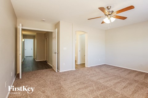 a living room with carpet and a ceiling fan