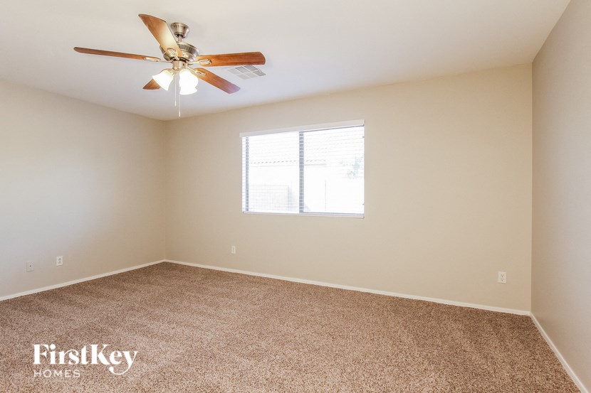 a empty room with a ceiling fan and a window