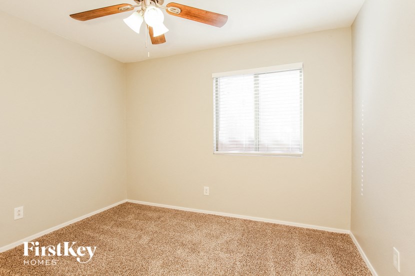 a bedroom with a ceiling fan and a window