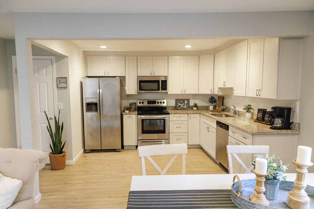 A modern kitchen with white cabinets and stainless steel appliances.