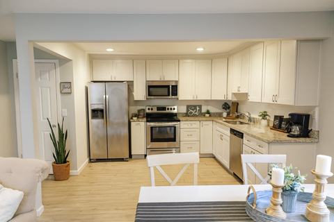 A modern kitchen with white cabinets and stainless steel appliances.
