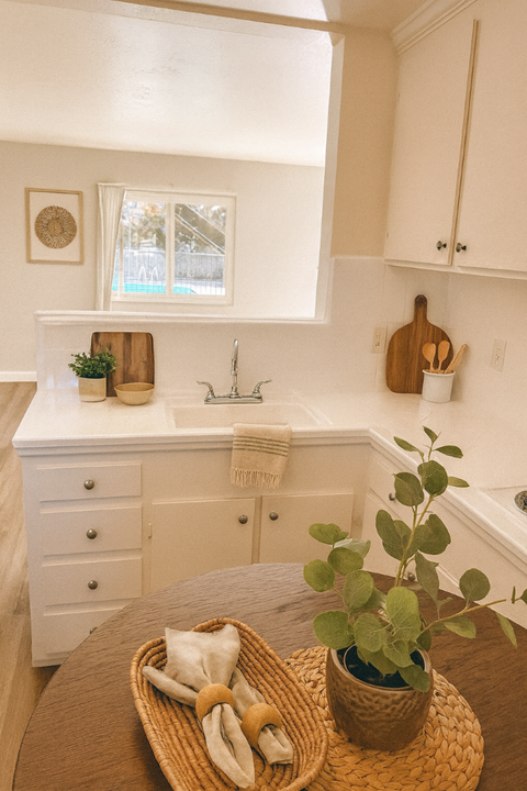A kitchen with a white counter and a basket on the table.