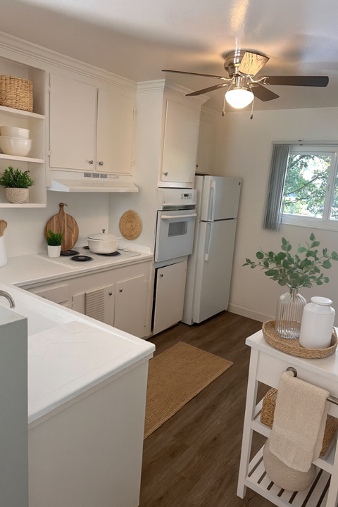A kitchen with white cabinets and a white refrigerator.