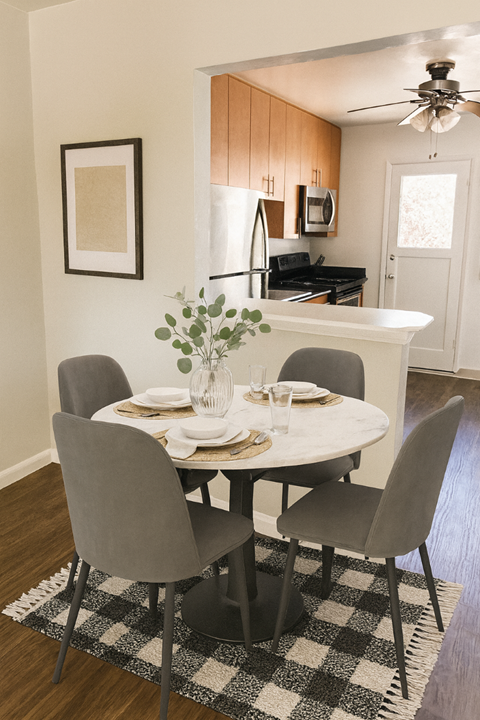 A dining room with a white table and chairs.