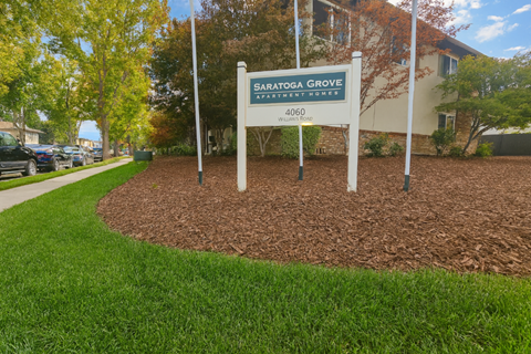 A sign for Satogga Grove Apartment Homes stands in a grassy area.