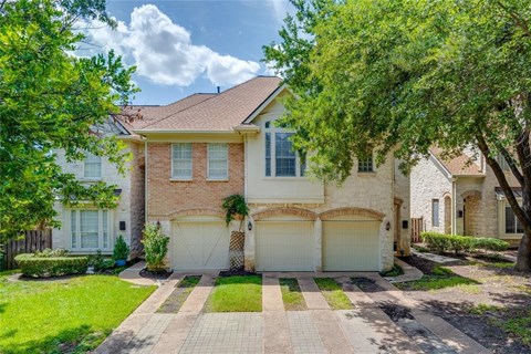 A house with a driveway and garage doors.