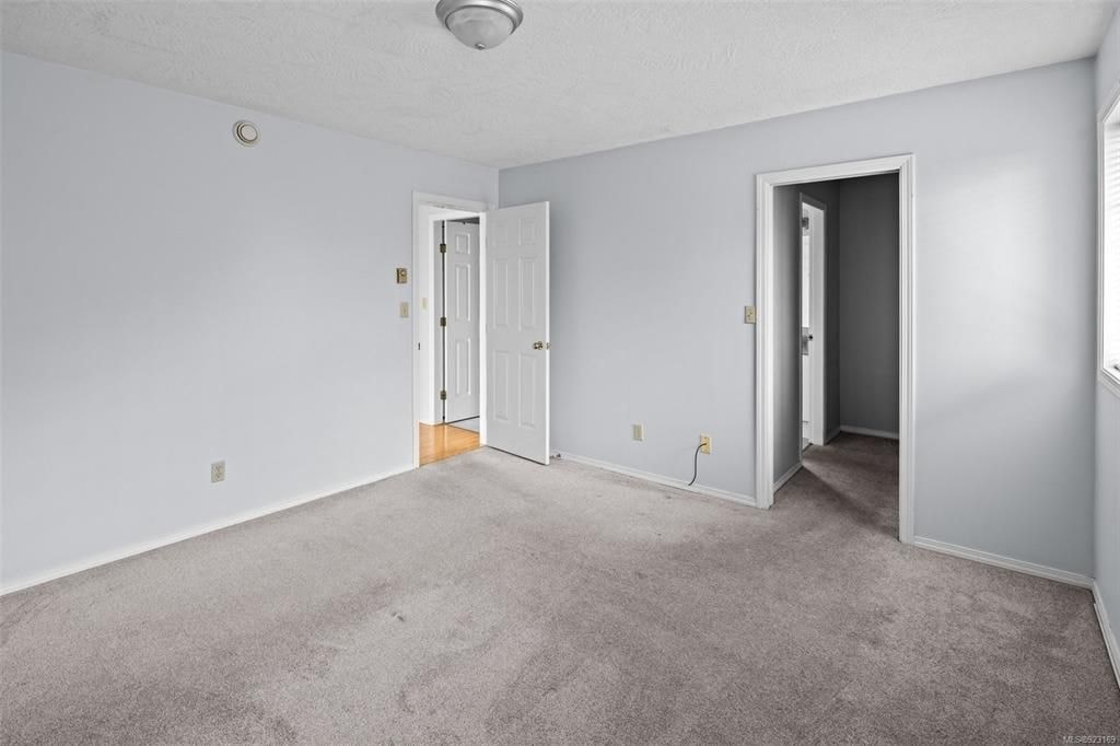 A room with two doors and a carpeted floor.