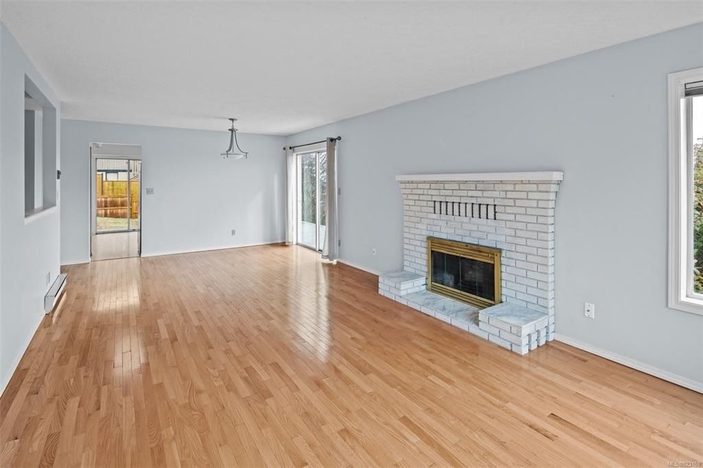 A room with a fireplace and wood flooring.