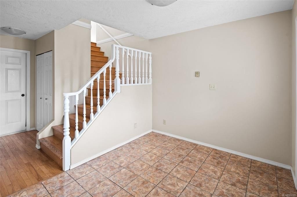 A room with a staircase and tile flooring.