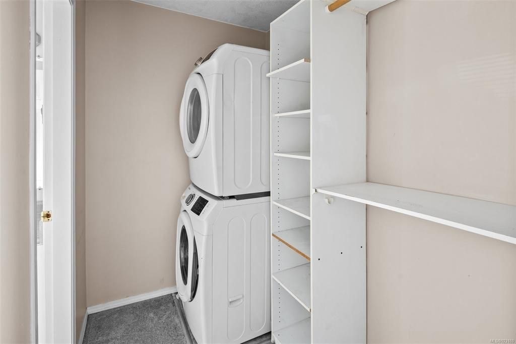 A stack of white washing machines in a laundry room.