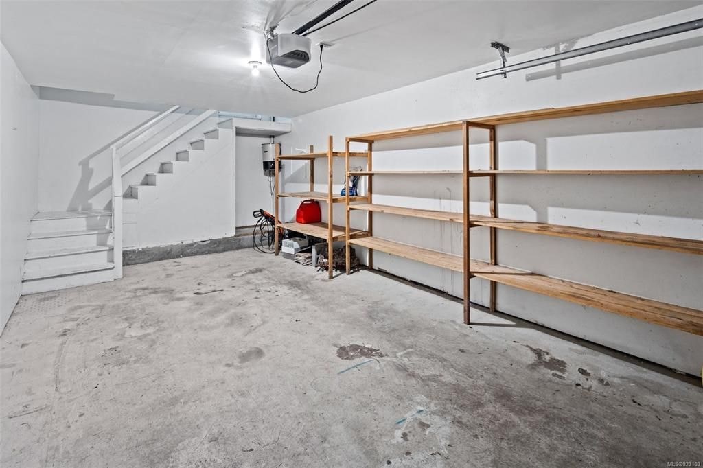 A room with a staircase and a wall of shelves.