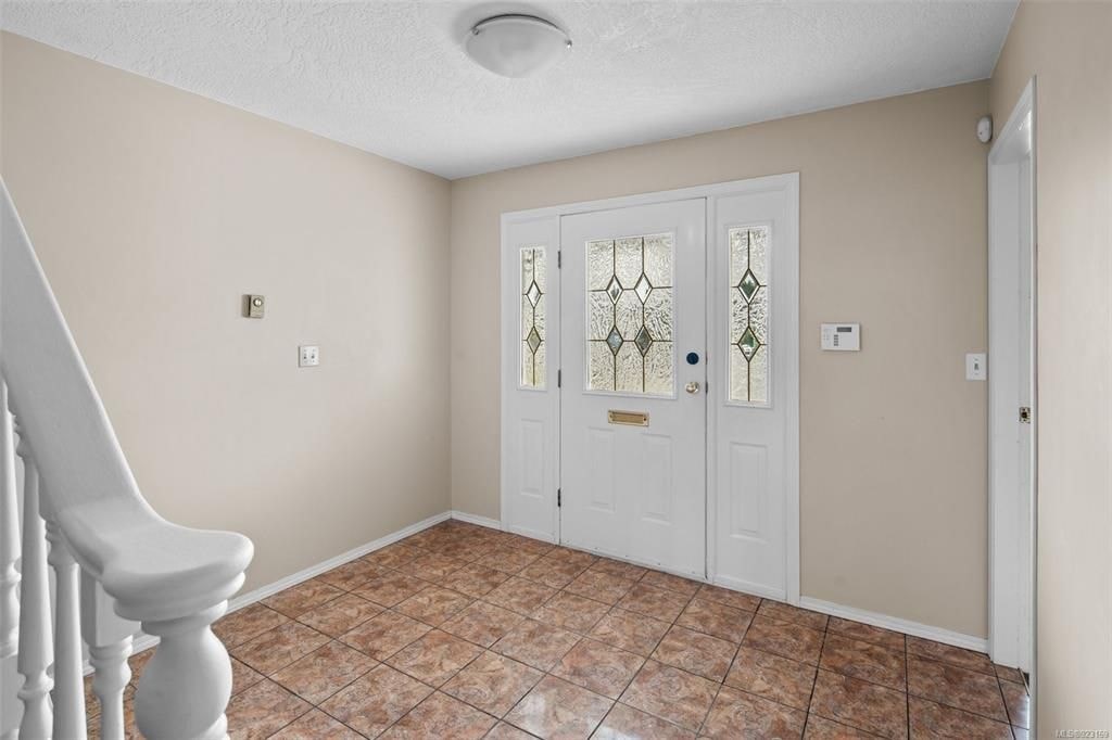 A room with a tiled floor and a white door with glass panels.